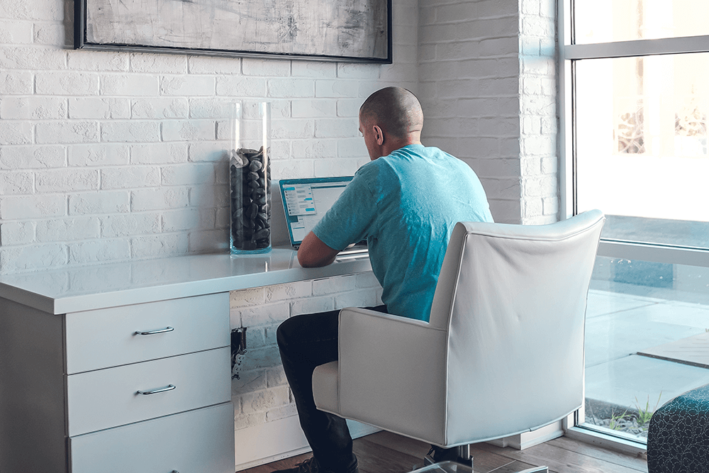 Millennial sitting as a desk working on his laptop