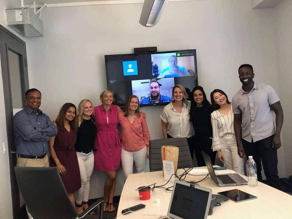 Nine WilsonHCG employees posing in a conference room