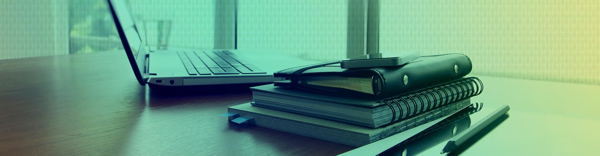 A stack of books next to a laptop.