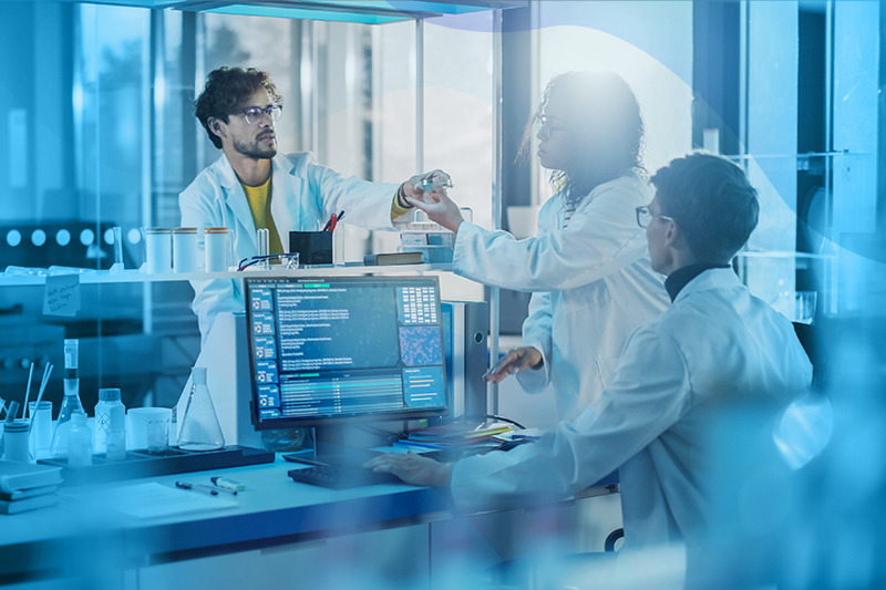 Group of scientists talking by a computer