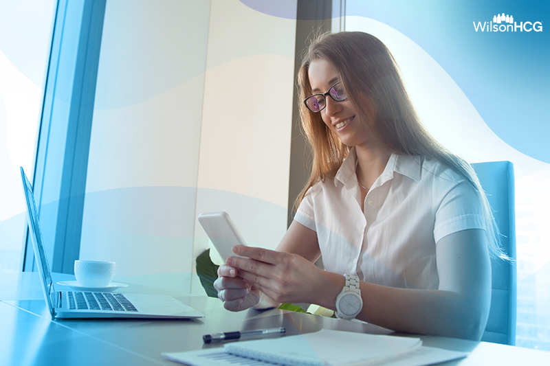 Girl at her work desk on her smartphone