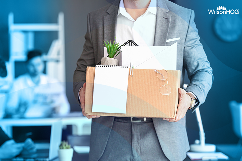 image of a man leaving his workplace carrying a box of his belongings