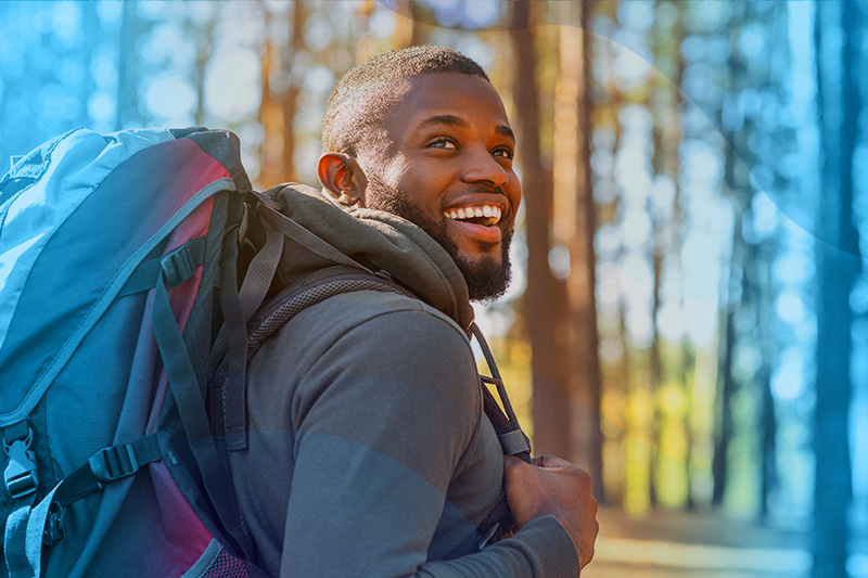 photo of a happy man hiking through a forest