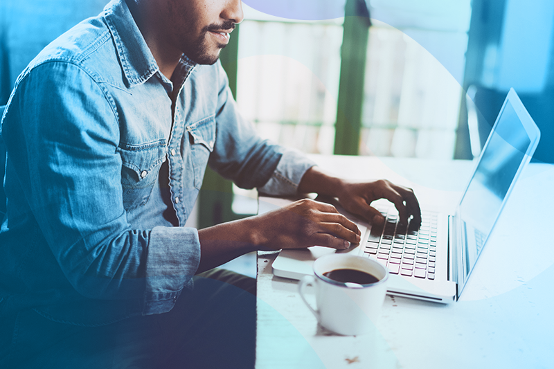 man on his laptop with a cup of coffee next to him