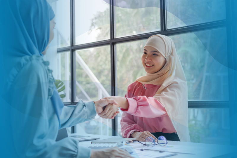 Two businesswomen shaking hands when working together at an office.