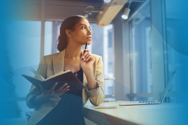 Afro american female executive thinking and using a notebook.