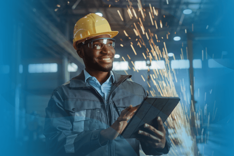 African American industrial engineer wearing safety uniform and hard hat uses tablet computer. 