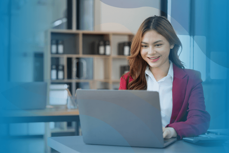 Young businesswoman sitting at her desk typing on a laptop