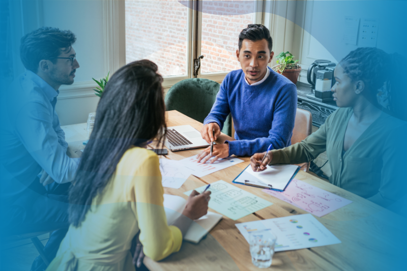 Group of office employees around a table talking