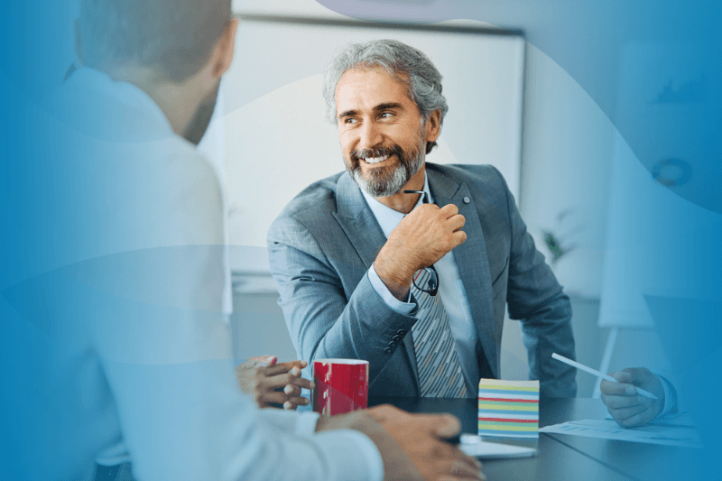 Senior businessman smiling during a meeting.