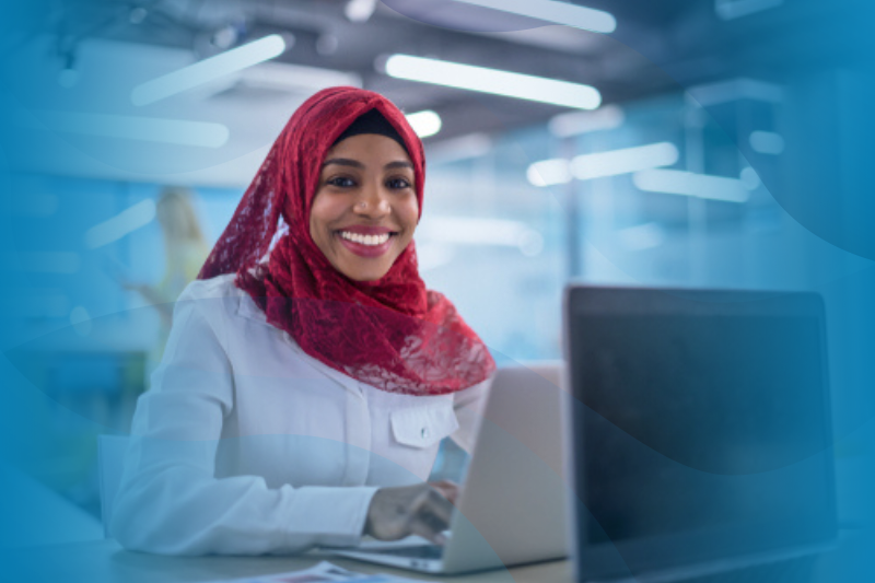 Black Muslim Business Woman Wearing a Red Hijab and Working on a Laptop