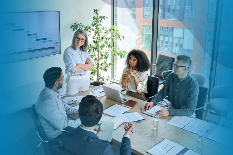 Female CEO and multicultural business people discussing company presentation at boardroom table