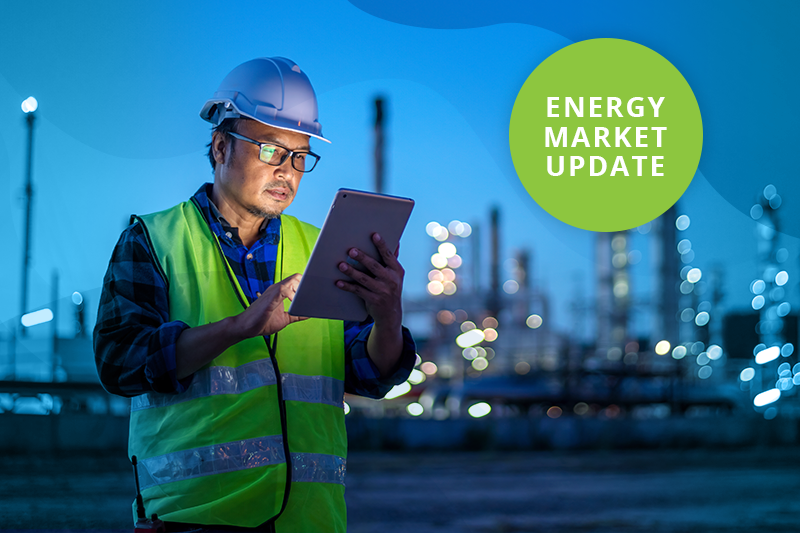 Engineer Wearing Safety Uniform and Helmet Looking at Tablet with Oil Refinery Factory in Background