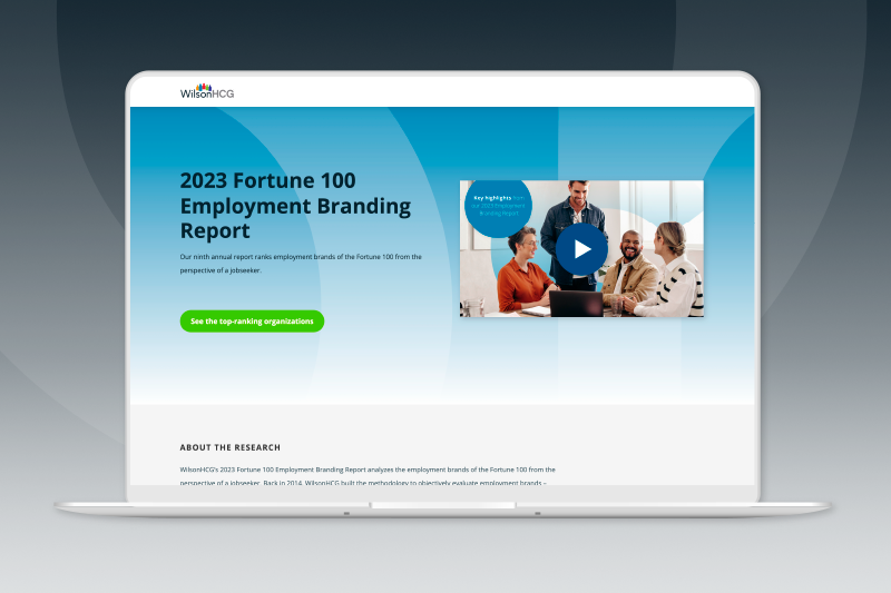 Laptop screen with WilsonHCG 2023 Fortune 100 Employment Branding Report website screenshot in front of website page