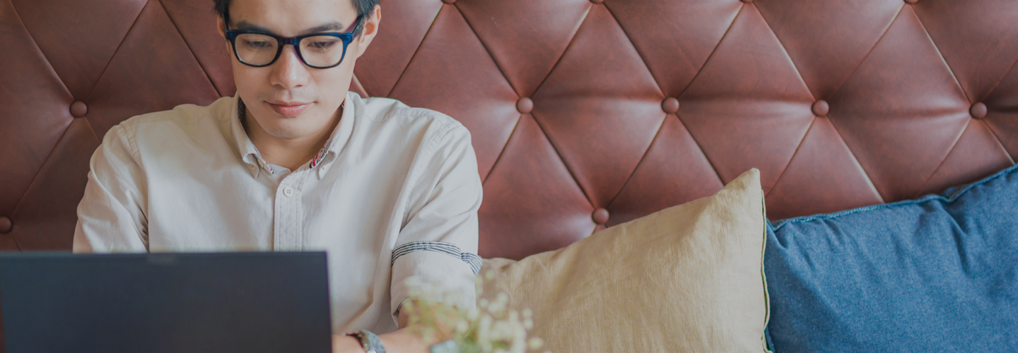 Person at couch working on laptop