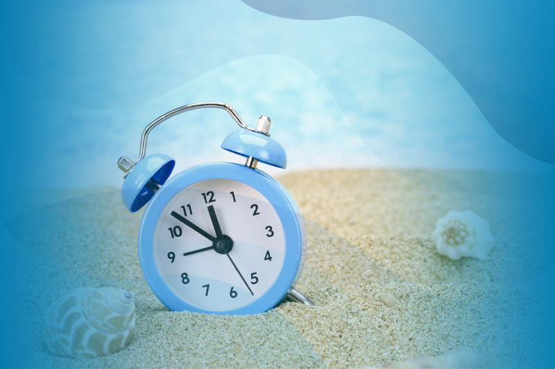Seashells And A Blue Alarm Clock On The Sand