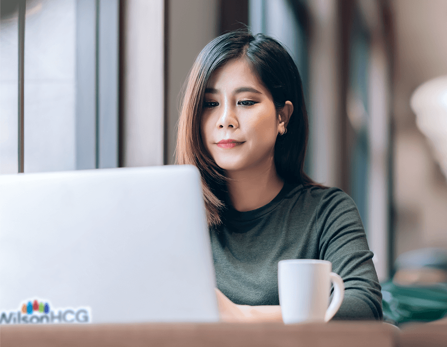 Neurodivergent employee at WilsonHCG sitting with her laptop