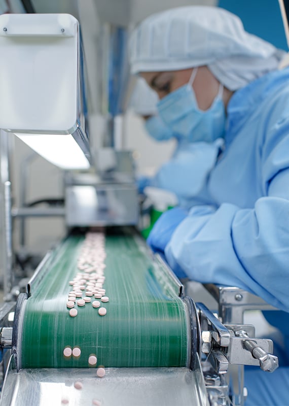 Pharmaceutical employee working on production line