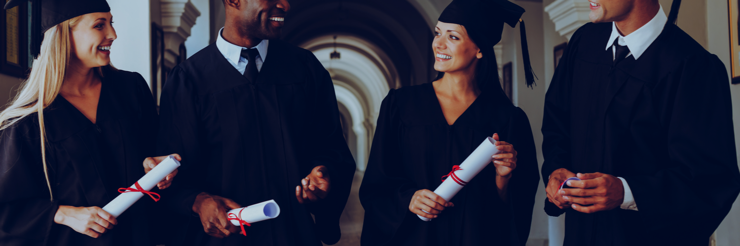 Two graduates holding degrees looking at each other smiling